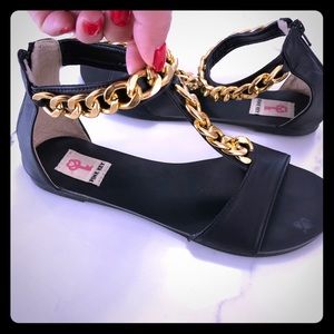 Black sandals with gold chain detail